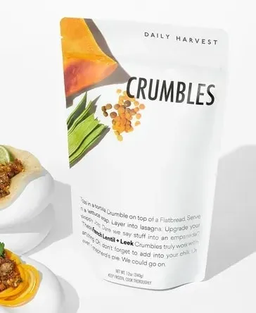 12oz white pouch with the words “Daily Harvest” at the top, a large “CRUMBLES” immediately below the top, and the words “French Lentil + Leek” in bold.